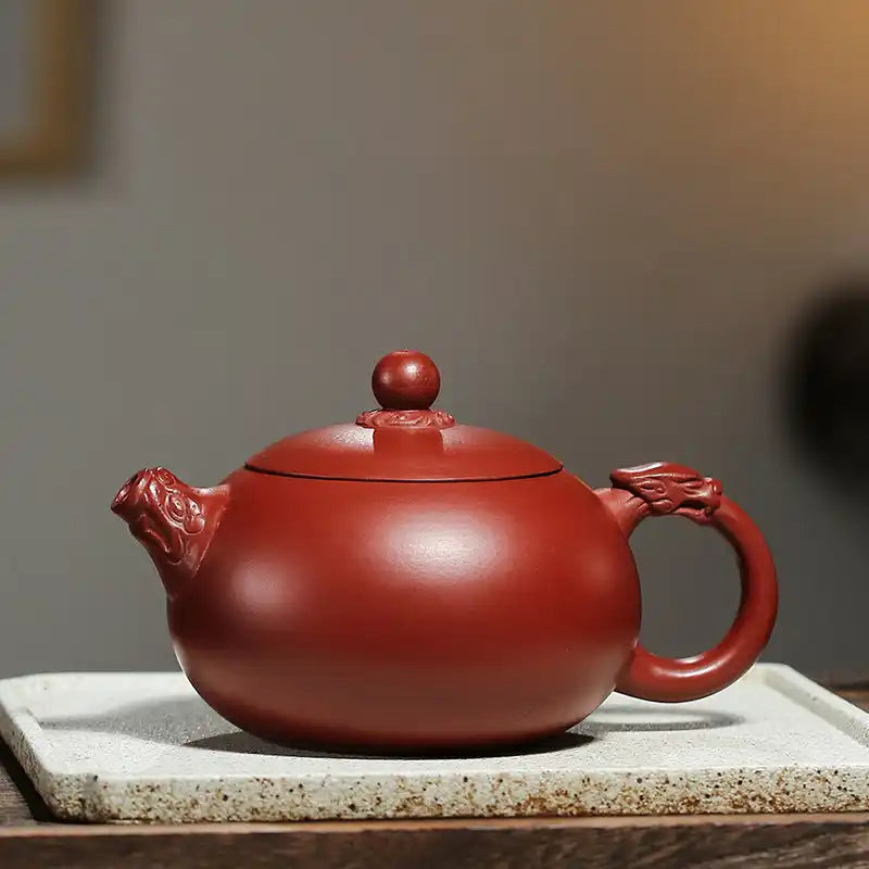 Reddish-brown ceramic teapot with dragon-shaped handle and spout.