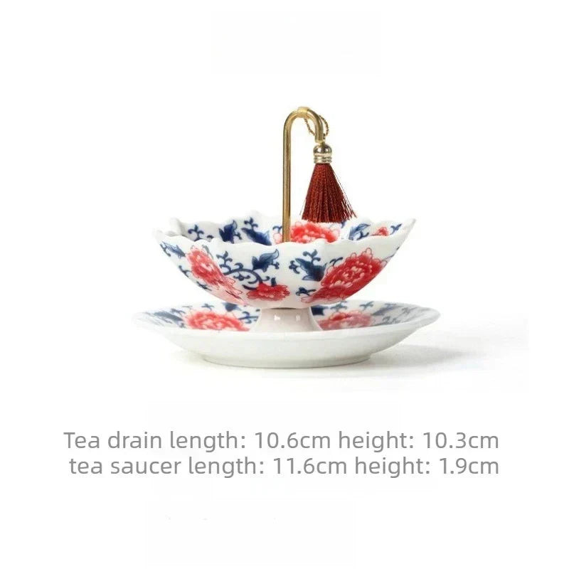 Blue and white ceramic umbrella tea strainer with a brass hook handle resting on its saucer