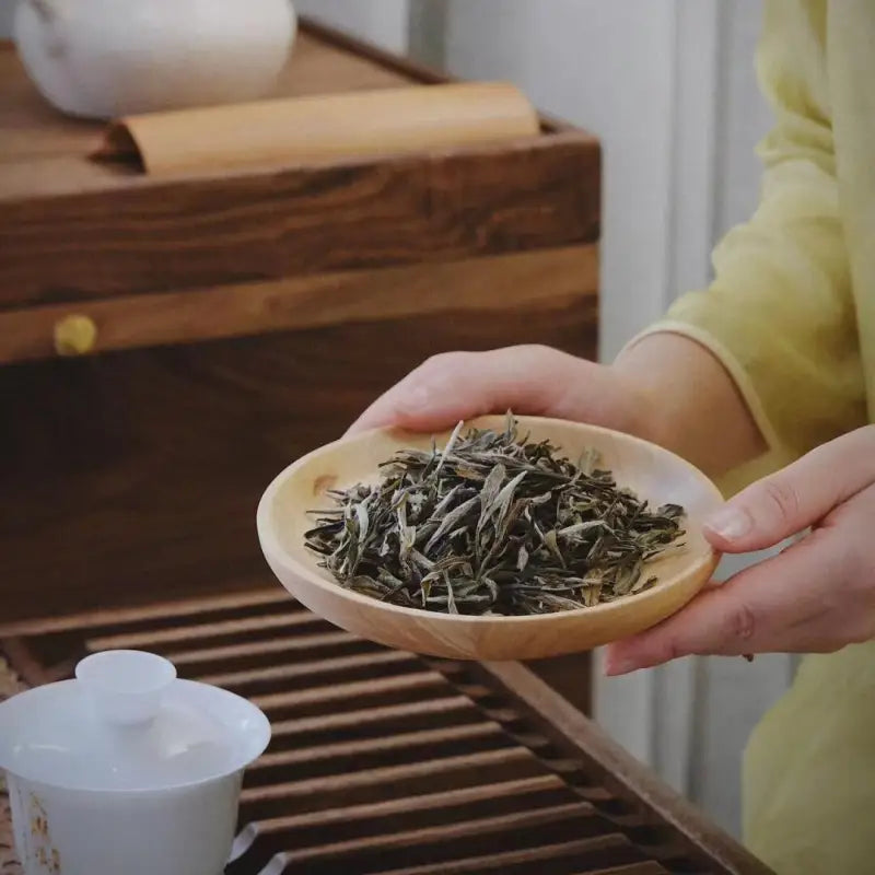 Wooden dish of bai mu dan white tea leaves from 2020 Bai Mu Dan White Tea product