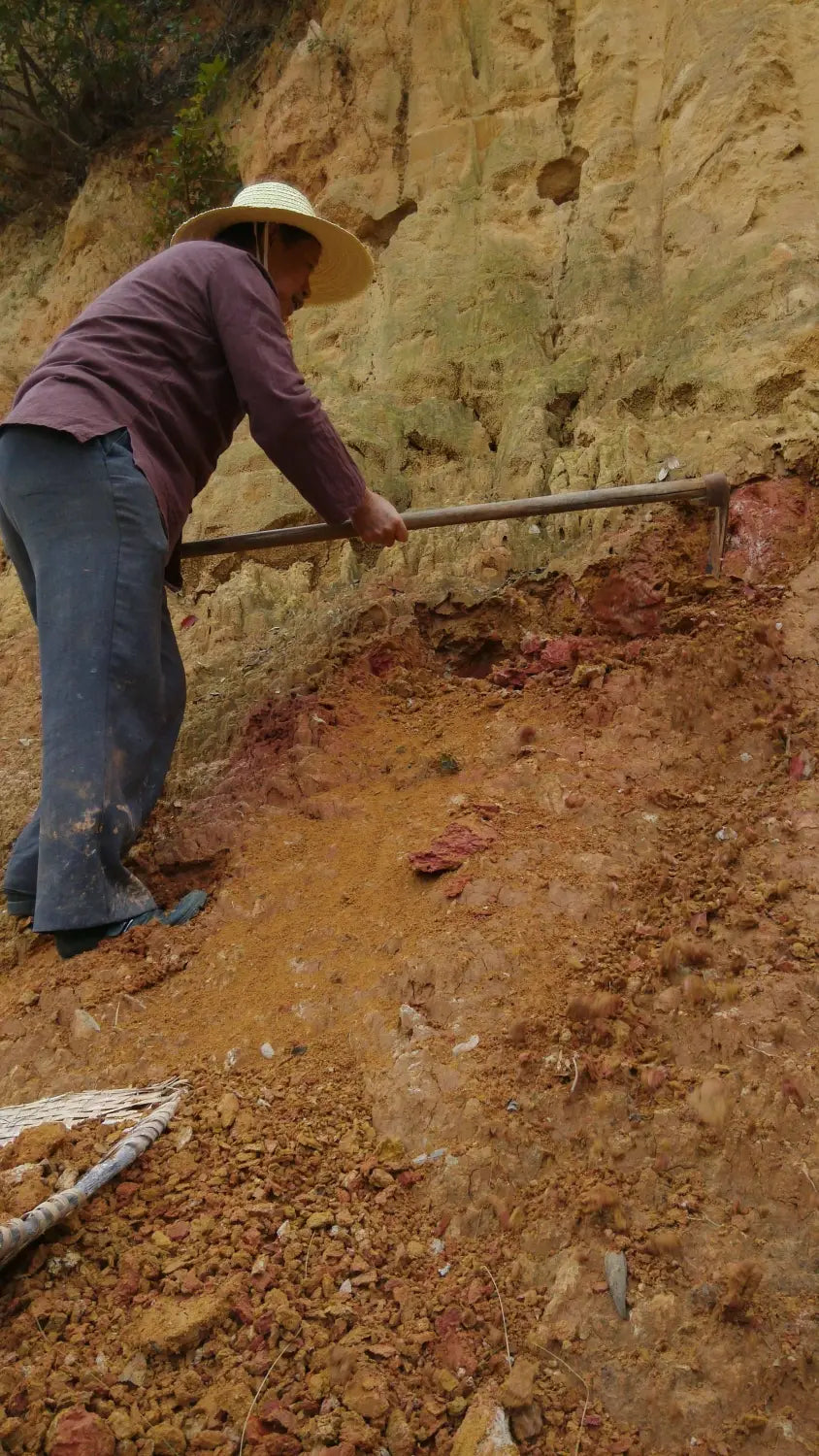 Une personne creusant dans la colline présente la technique d'incrustation de poterie Jianshui Zitao avec de l'argile à cinq couleurs