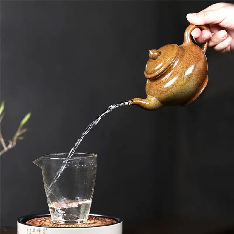 Brown ceramic Yixing Duanni teapot pouring water from Amber Flow made of Duanni clay