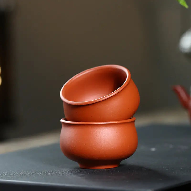 Stacked terracotta tea cups from Amber showcasing authentic Yixing Zisha craftsmanship