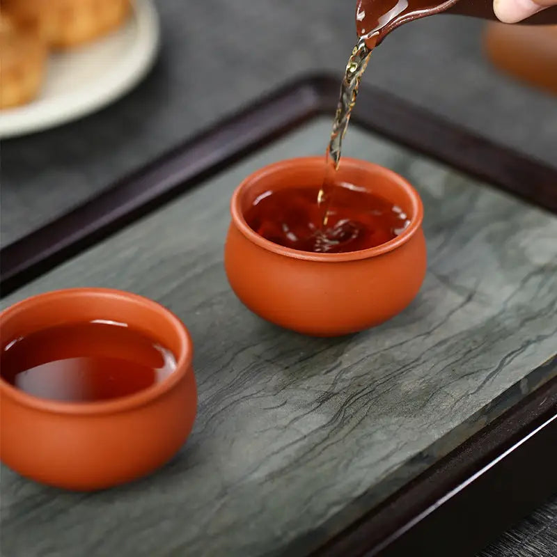 Two terracotta teacups from the Amber Harmony collection showcasing authentic Yixing Zisha craftsmanship