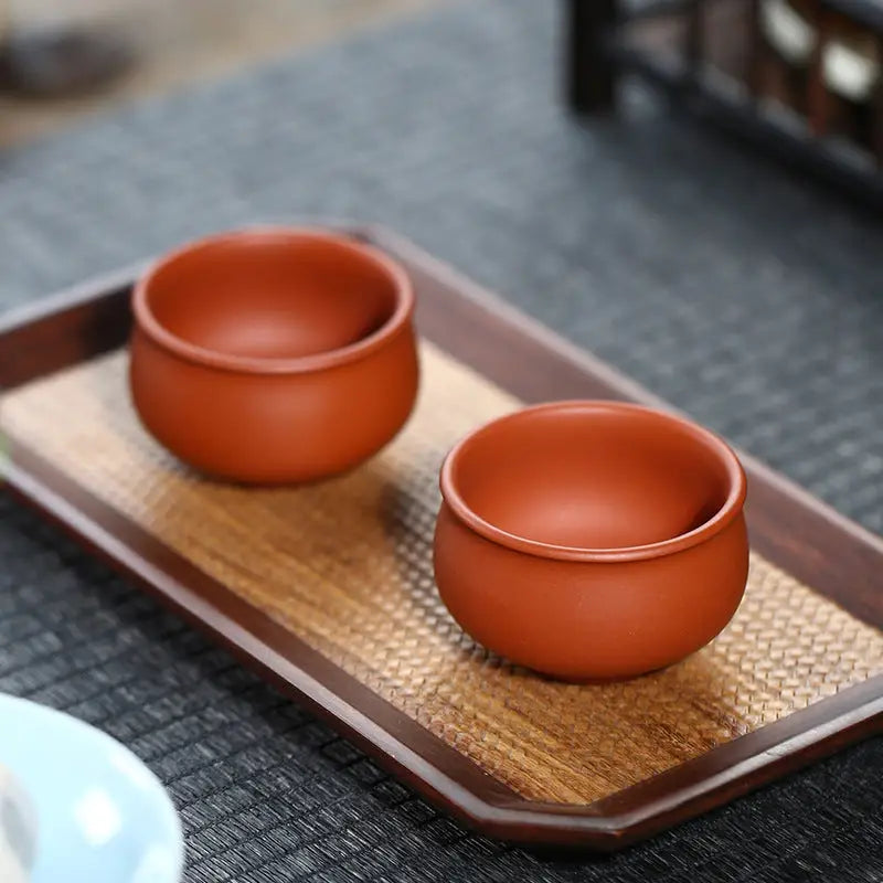 Two terracotta teacups from Amber showcasing authentic Yixing Zisha craftsmanship