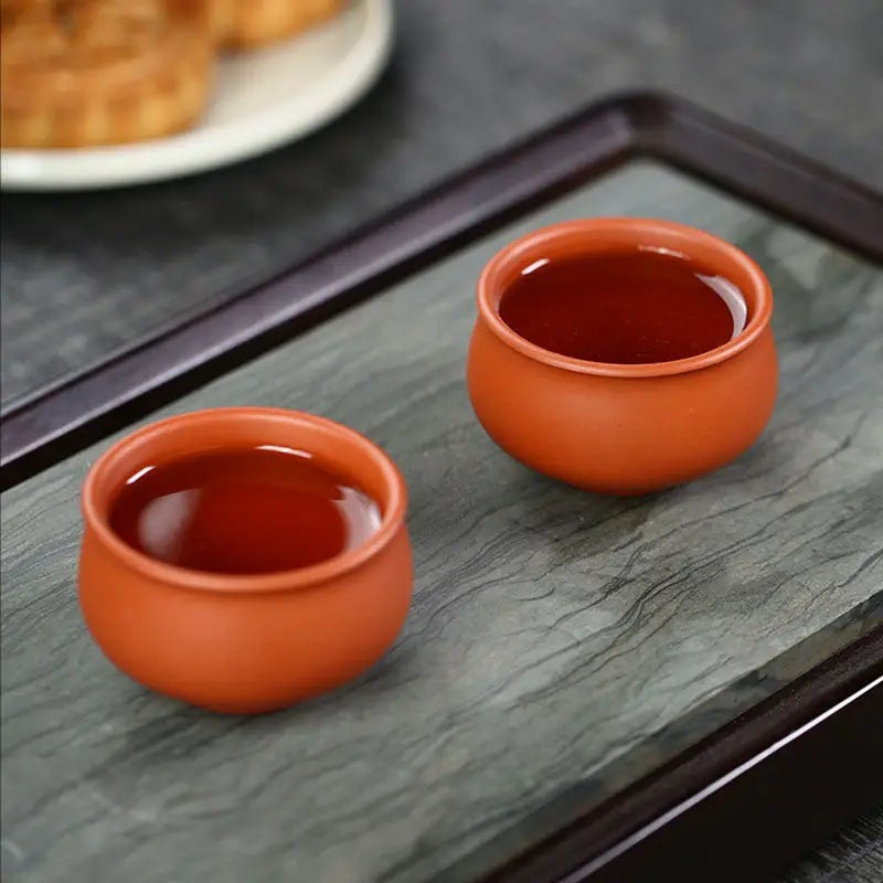 Two terracotta teacups from Amber showcasing authentic Yixing Zisha craftsmanship