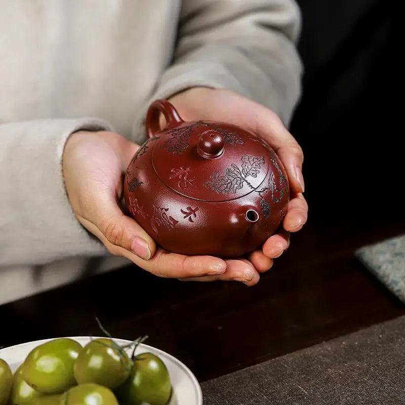 Maroon Yixing Zisha teapot with etched tree design from Ancient Plum Tree collection
