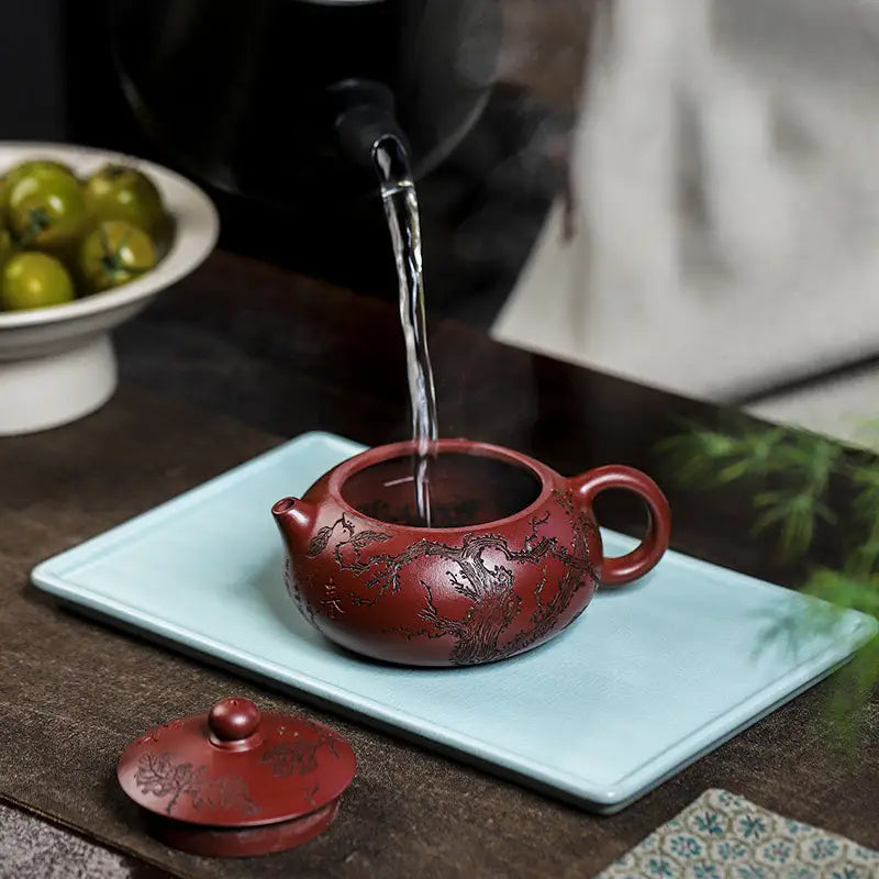 Reddish-brown Yixing Zisha teapot with intricate dark etchings from Ancient Plum Tree