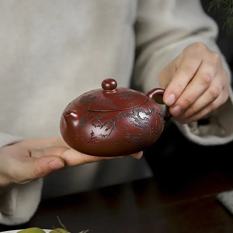 Reddish-brown ceramic teapot with etched dragon design from Ancient Plum Tree Yixing Zisha collection