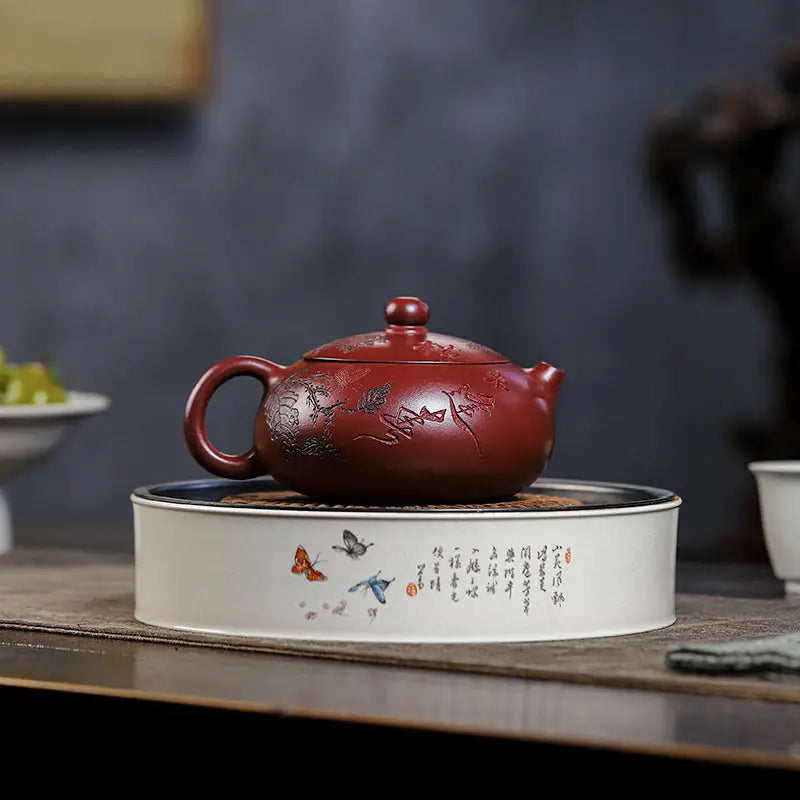 Maroon teapot from Ancient Plum Tree Yixing Zisha collection on decorative warmer