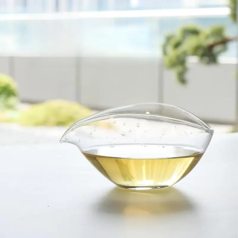 Clear glass pitcher with yellow liquid featuring authentic Anxi Tie Guan Yin Oolong Tea