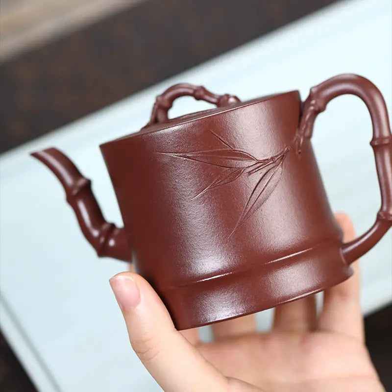 Brown ceramic Yixing Zisha teapot with bamboo accents, ideal for Gongfu tea brewing