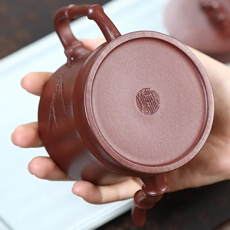 Maroon clay Yixing Zisha teapot with bamboo handle for Gongfu tea brewing in the Bamboo Echo collection