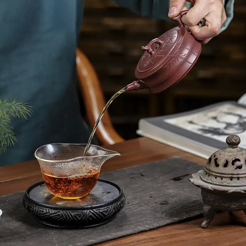 Reddish-brown Yixing Zisha Bamboo Grove teapot with hand-carved bamboo pattern pouring tea