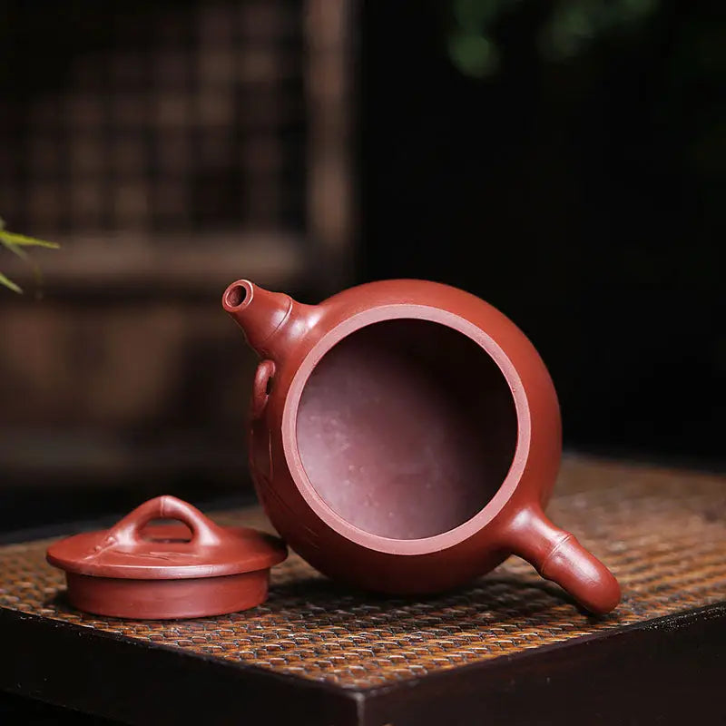 Maroon clay teapot with lid from Bamboo Zen featuring carved bamboo design and Yixing Zisha style