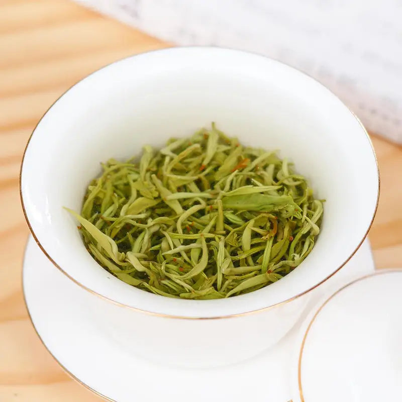 White teacup filled with Green Tea Leaves from Bi Luo Chun Green Tea Set
