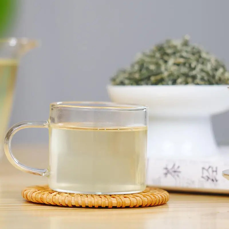 Clear glass teacup with light-colored Bi Luo Chun Green Tea Leaves, perfect for tea sets