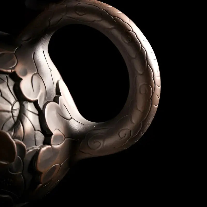 Ornate dark-toned handle on Bloom jianshui zitao teapot showcasing purple pottery art