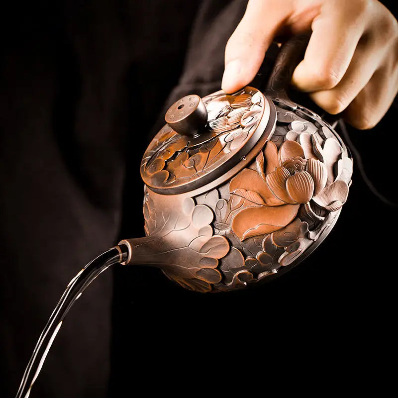 Ornate bronze teapot pouring water in Bloom II, showcasing Zitao teapot design and purple clay modern tea