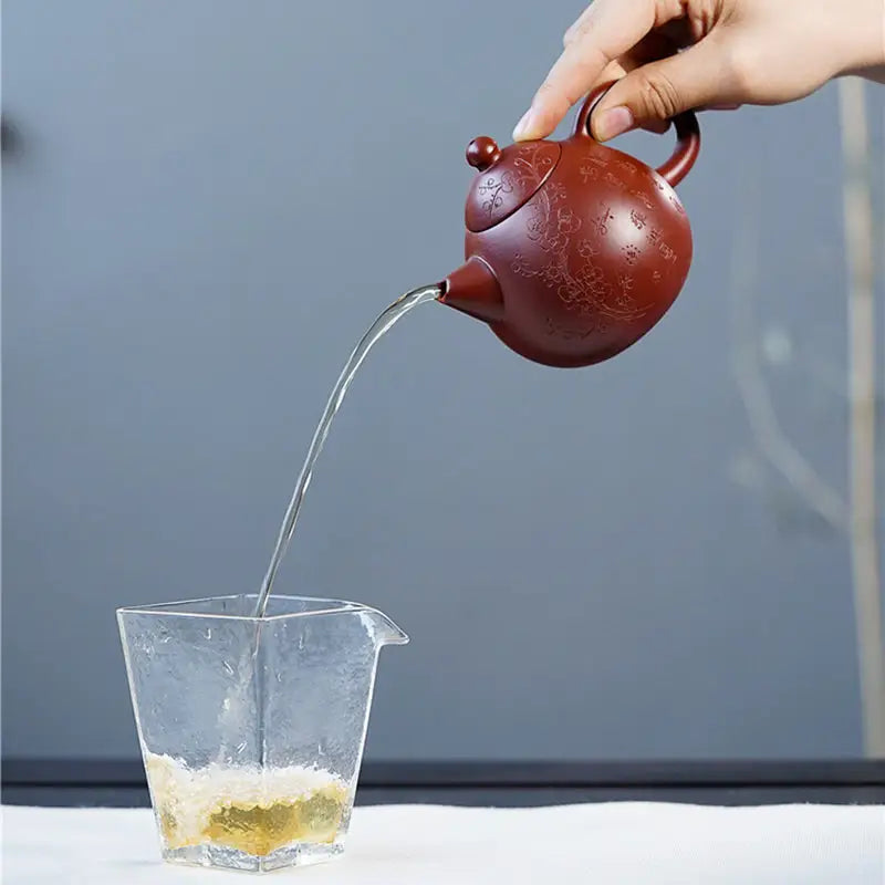 Brown Yixing Zisha teapot pouring liquid from Blossom Verse Yixing Teapot for tea brewing