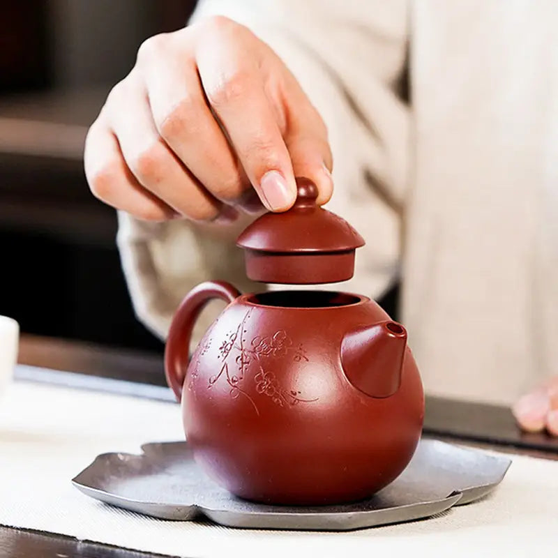 Redish-brown Blossom Verse Yixing Zisha teapot with floral design and separate lid