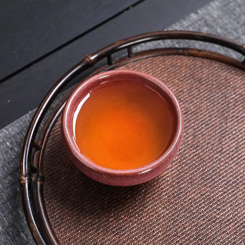 Tea-filled reddish-brown Jian Zhan teacup from the Blush Gongfu Tea collection