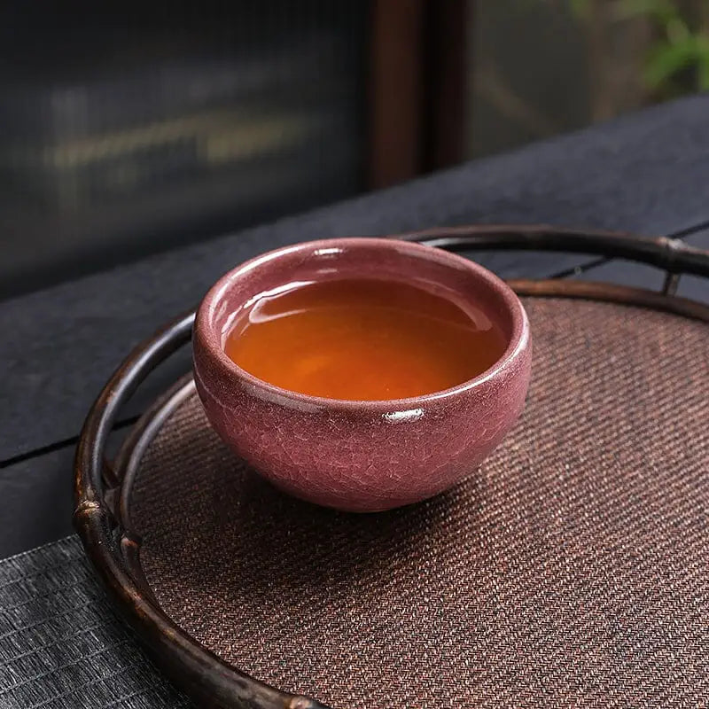 Maroon Jian Zhan teacup filled with gongfu tea for authentic tea experience