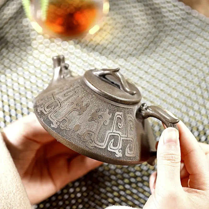 Ornate silver teapot with tribal dragon motif, part of the Bronze Dragon Yixing Zisha collection