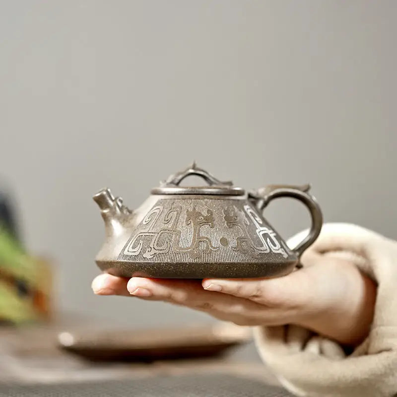 Ornate silver teapot with tribal dragon motif on Bronze Dragon product featuring yixing zisha style