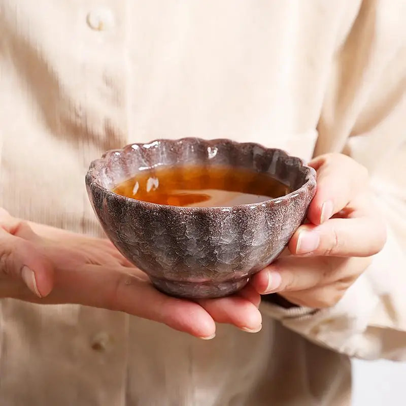 Jian Zhan ceramic bowl with glossy crystal glaze filled with liquid, showcasing crackled minerals