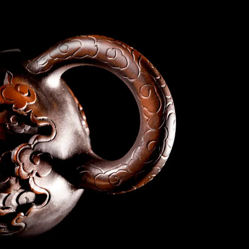 Ornate dark brown jianshui zitao teapot handle with hand-carved dragon carving dragon design
