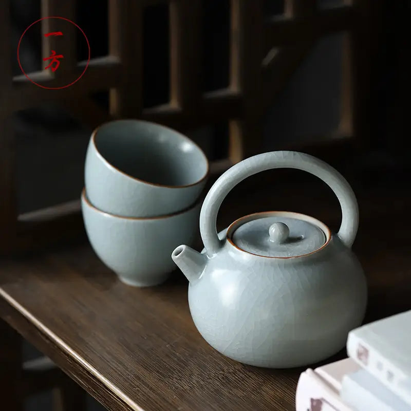 Light blue Celadon Ru Kiln crackle glaze teapot with matching cups, showcasing Tianqing glaze
