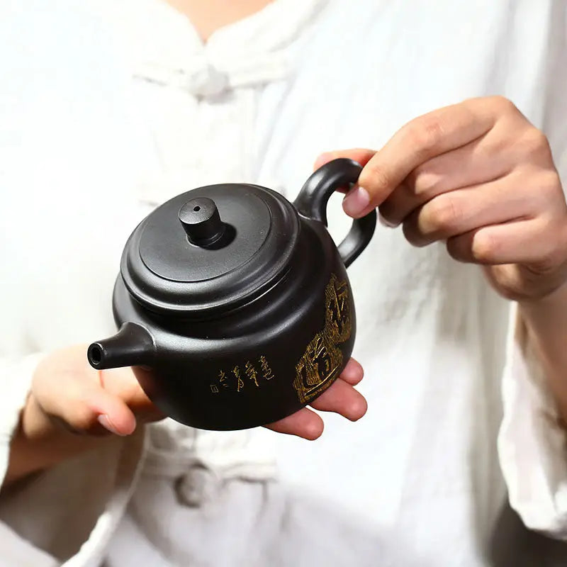 Dark ceramic Celestial Script Yixing Zisha Teapot with handle on zisha clay background