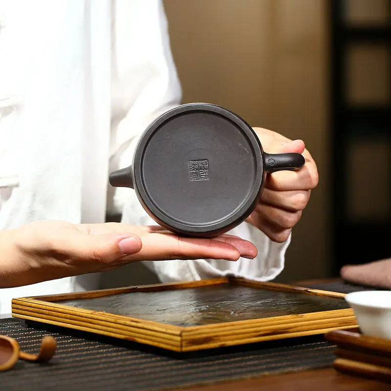 Dark round teapot bottom crafted from zisha clay in the Celestial Script Yixing teapot collection