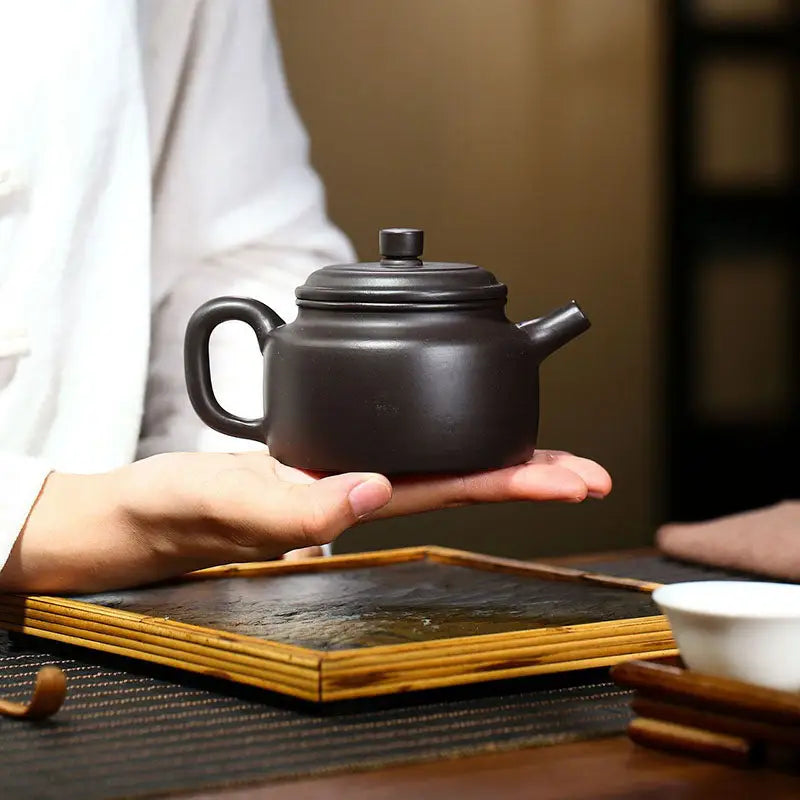 Dark brown ceramic teapot in Celestial Script Yixing style made from Zisha clay