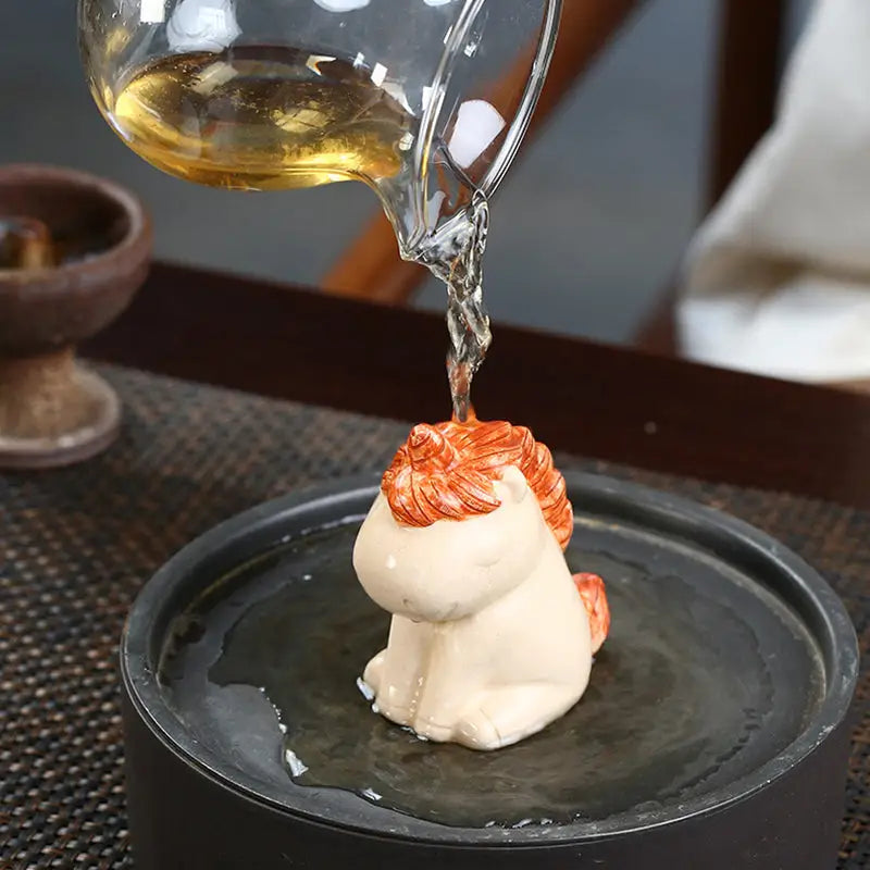 Ceramic Celestial Unicorn tea pet being poured on for feng shui energy enhancement