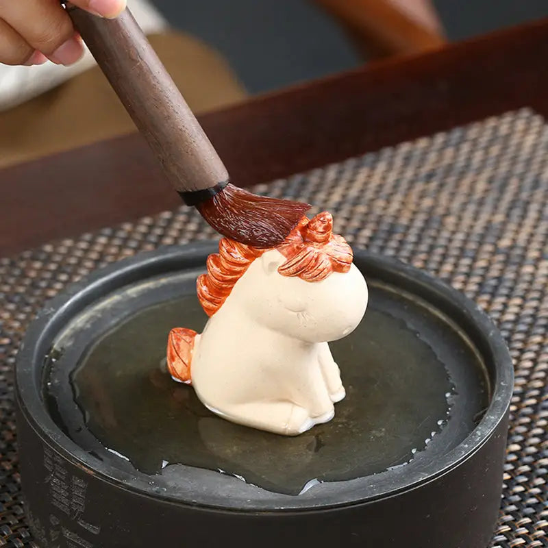 Ceramic Celestial Unicorn tea pet being brushed, perfect for tea pets guide and feng shui energy