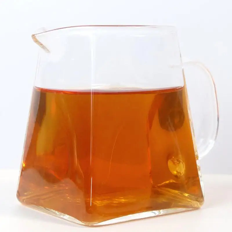 Square glass pitcher filled with amber liquid for Cinna Mon Rock Tea Leave tea set