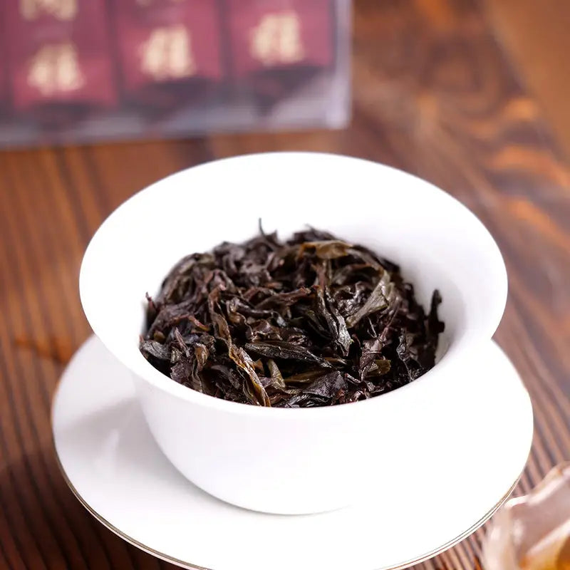 White bowl filled with dark Cinna Mon Rock Tea Leaves, perfect for tea sets and mugs