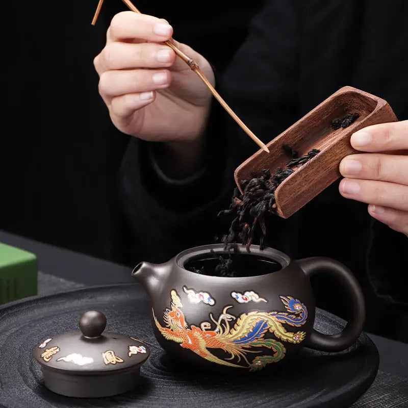 Decorated brown zisha teapot featuring a color-changing dragon and phoenix design
