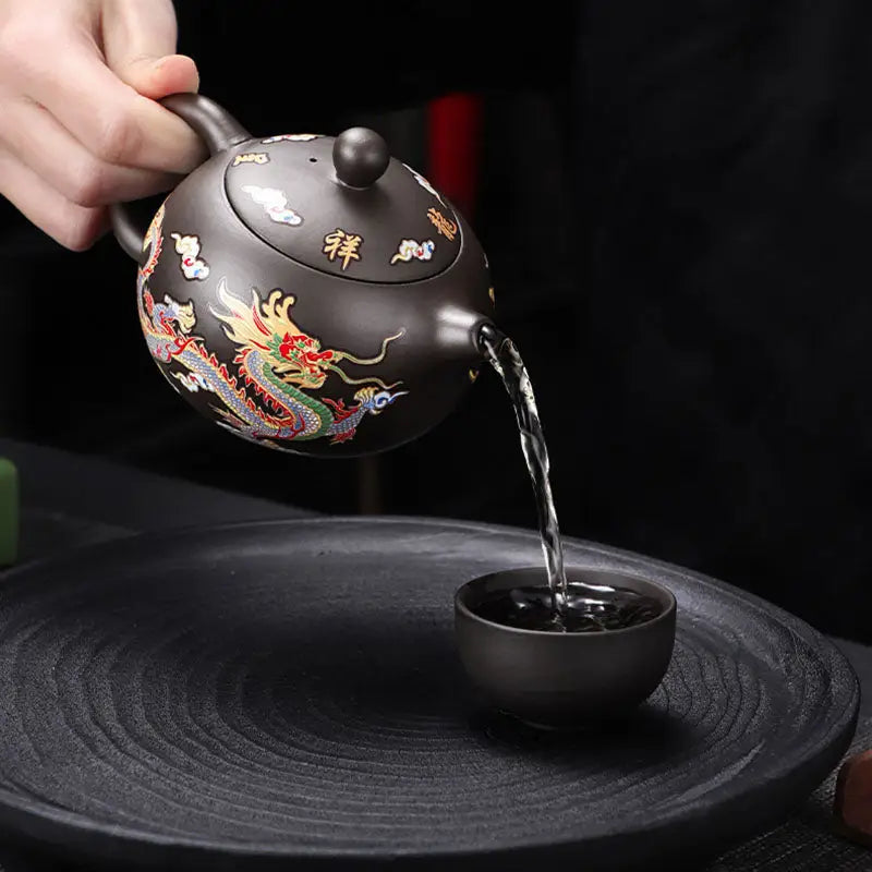 Color-changing dragon and phoenix Zisha Yixing teapot pouring liquid showcasing intricate design