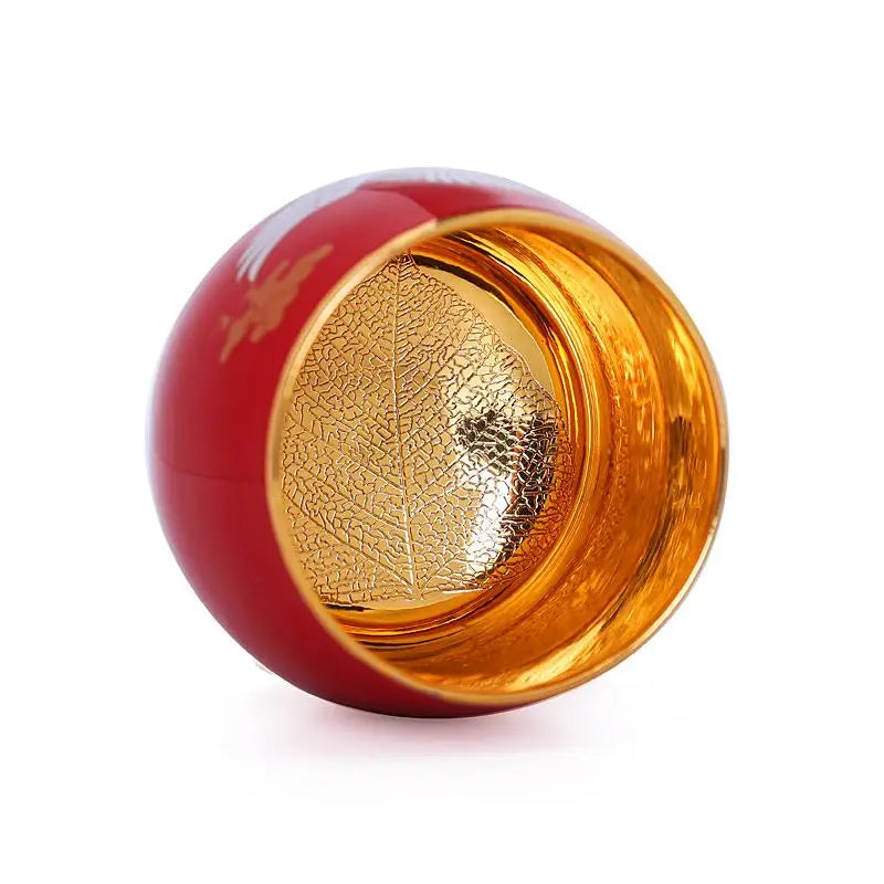 Red and gold decorative sphere from Jian Zhan Crane with red exterior and flying white crane design