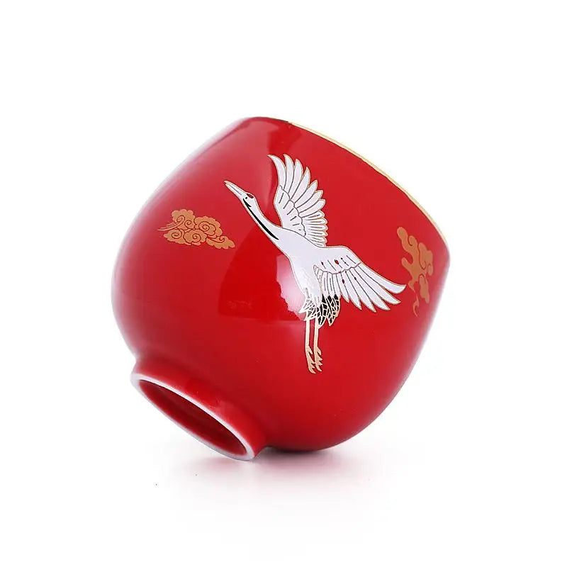 Red ceramic cup with flying white crane design, showcasing Jian Zhan craftsmanship
