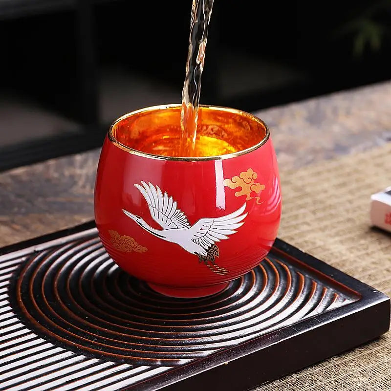 Red tea cup with crane design featuring jian zhan flying white crane motif and red exterior