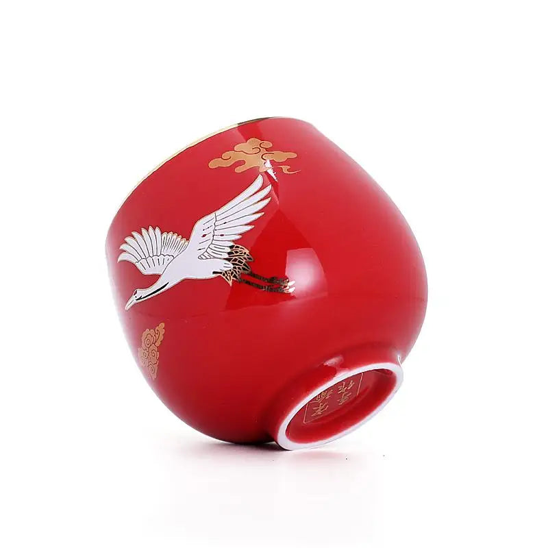 Red ceramic cup with crane design showcasing Jian Zhan style and flying white crane motif