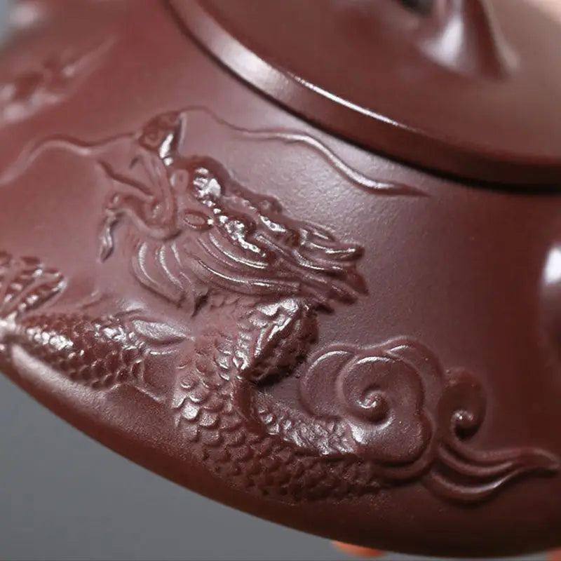 Creative Dragon Yixing Zisha Teapot featuring a maroon teapot with intricate dragon relief