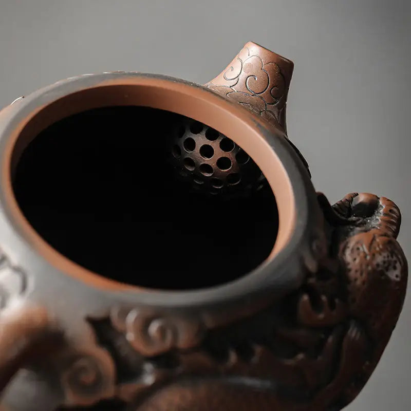 Ornate brown teapot interior showcasing dragon symbolism in hand-carved Jianshui Zitao clay