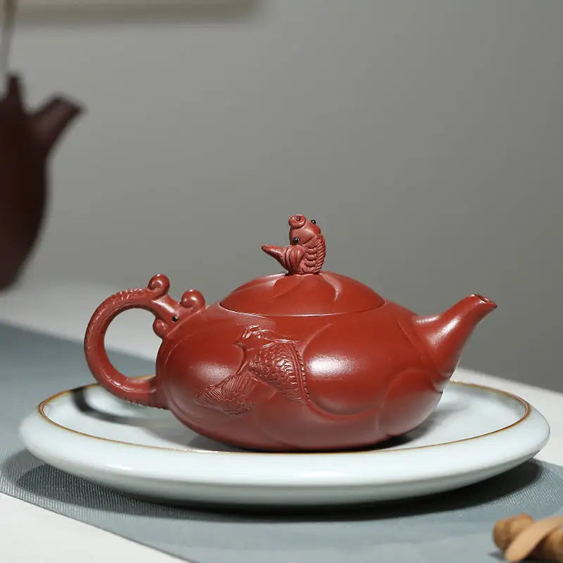 Reddish-brown Yixing teapot with fish-shaped lid featuring Carp Ascending design in Yixing Zisha clay