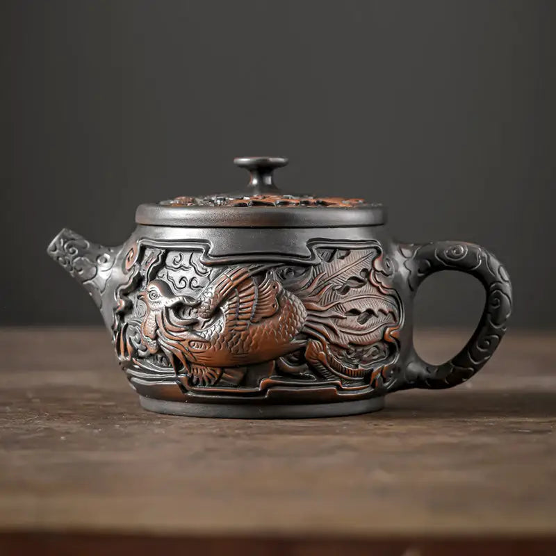 Ornate dark-colored Zitao tea pot with phoenix design, ideal for Jianshui Zitao teapot collectors