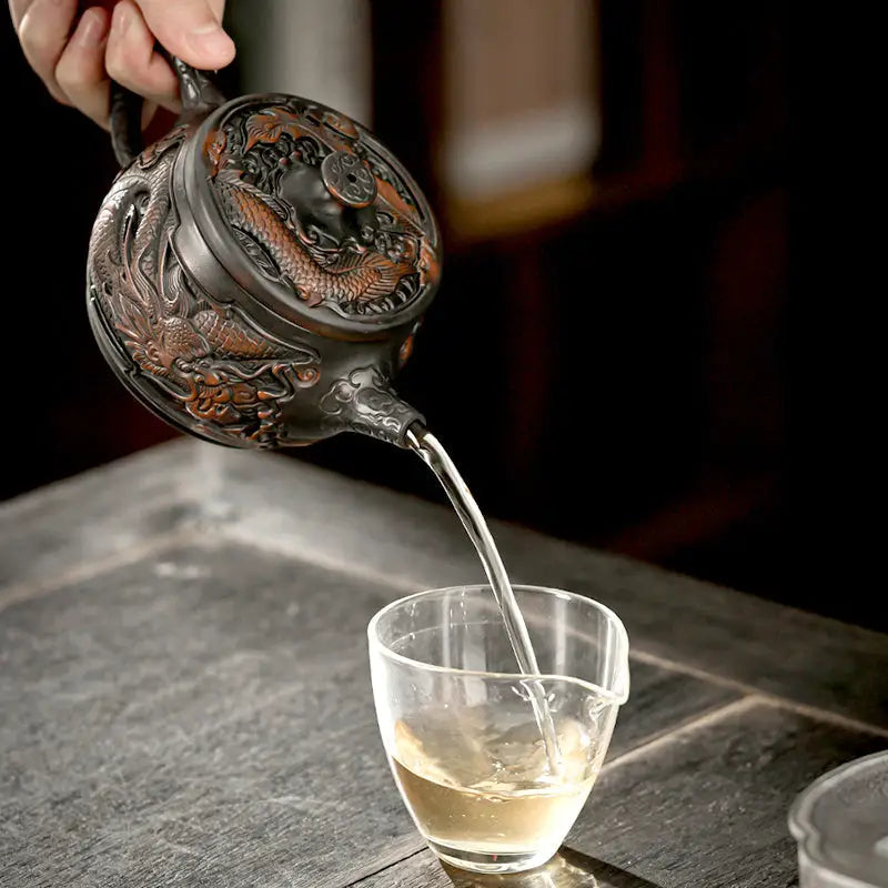Ornate dragon-themed jianshui zitao teapot pouring tea, perfect for purple clay gongfu tea and zitao tea pot enthusiasts