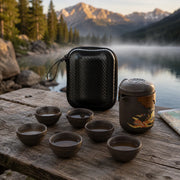 Dragon and phoenix Zisha travel tea set beside an alpine lake